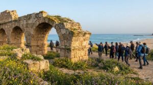 Early morning at Caesarea's Roman aqueduct, modern Israelis exploring, near the Mediterranean sea.