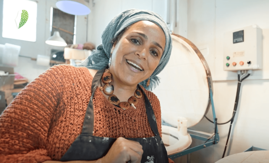 Batya shaping clay in her small studio