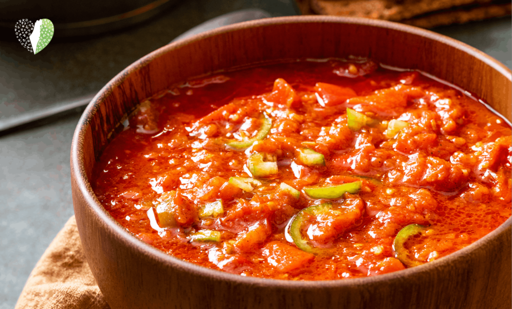 A bowl of matbucha with vibrant tomatoes and peppers