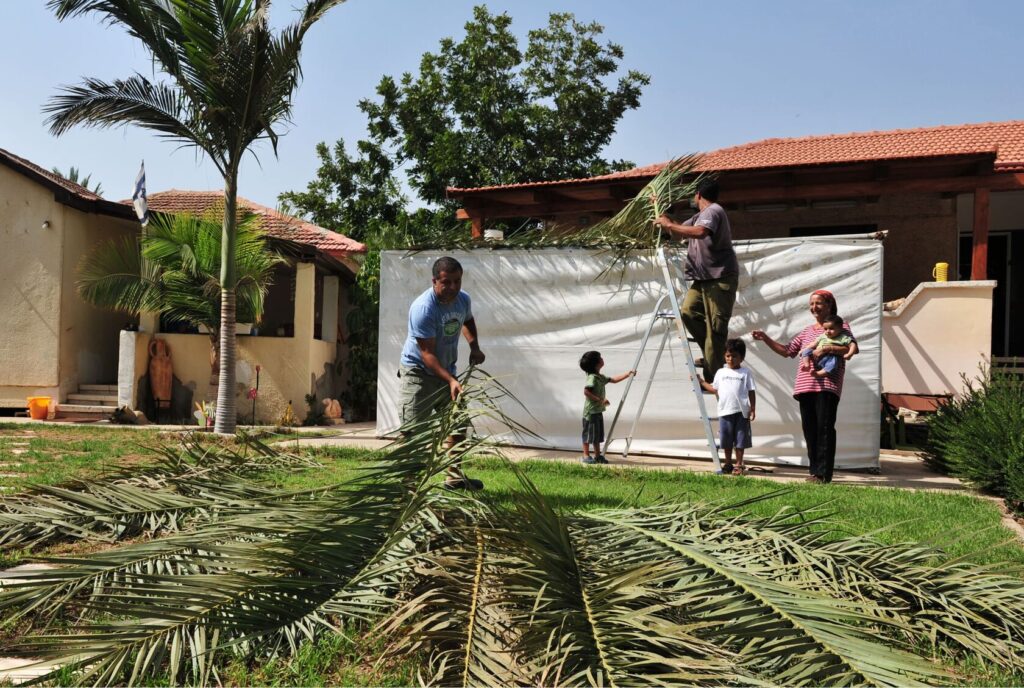 Children decorating a sukkah with colorful paper chains
