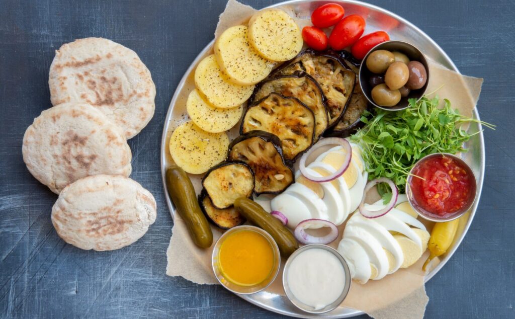 Street vendor preparing Sabich with fresh ingredients