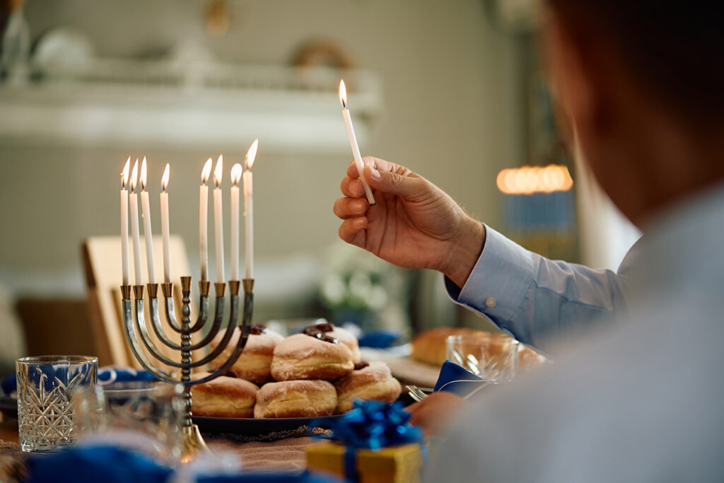 Family lighting candles on Hanukkah menorah